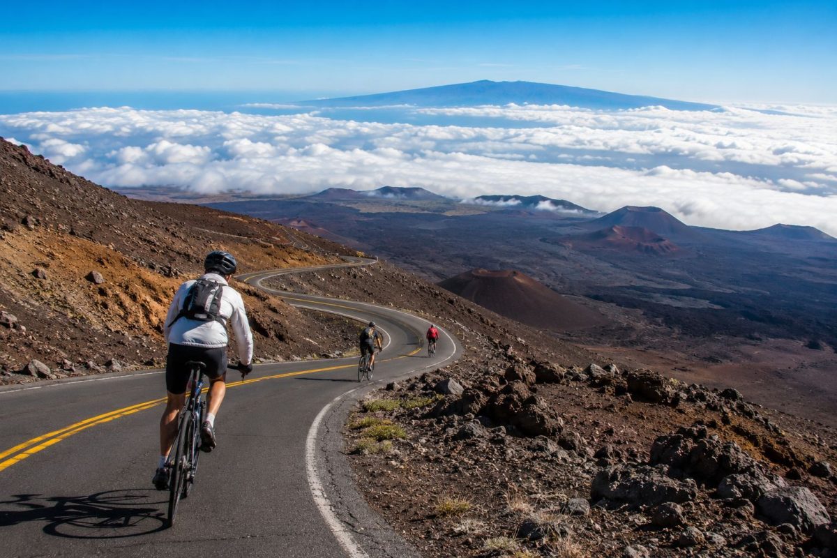Group of cyclists on a guided Haleakala downhill bike tour with ocean panorama