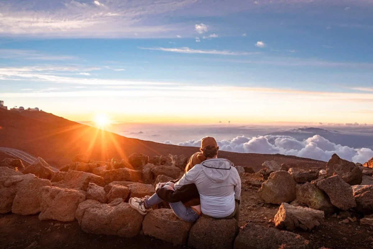 Haleakala sunrise with couple silhouette against volcanic crater landscape