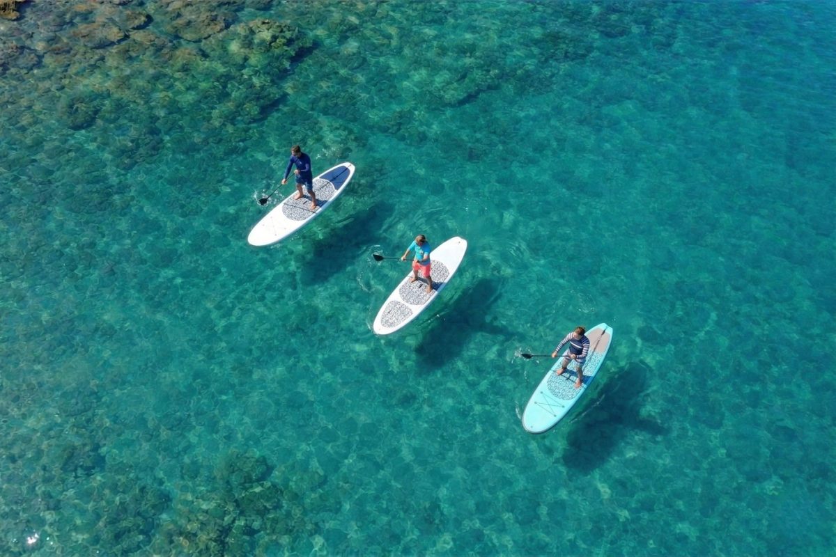 stand-up paddleboarding over coral reef South Maui clear water
